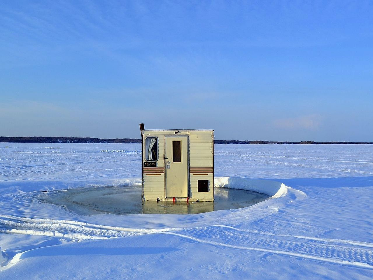 Un arroyo angosto corriendo bajo el hielo pálido